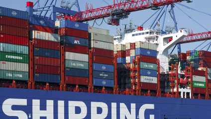 A container ship in port with cranes